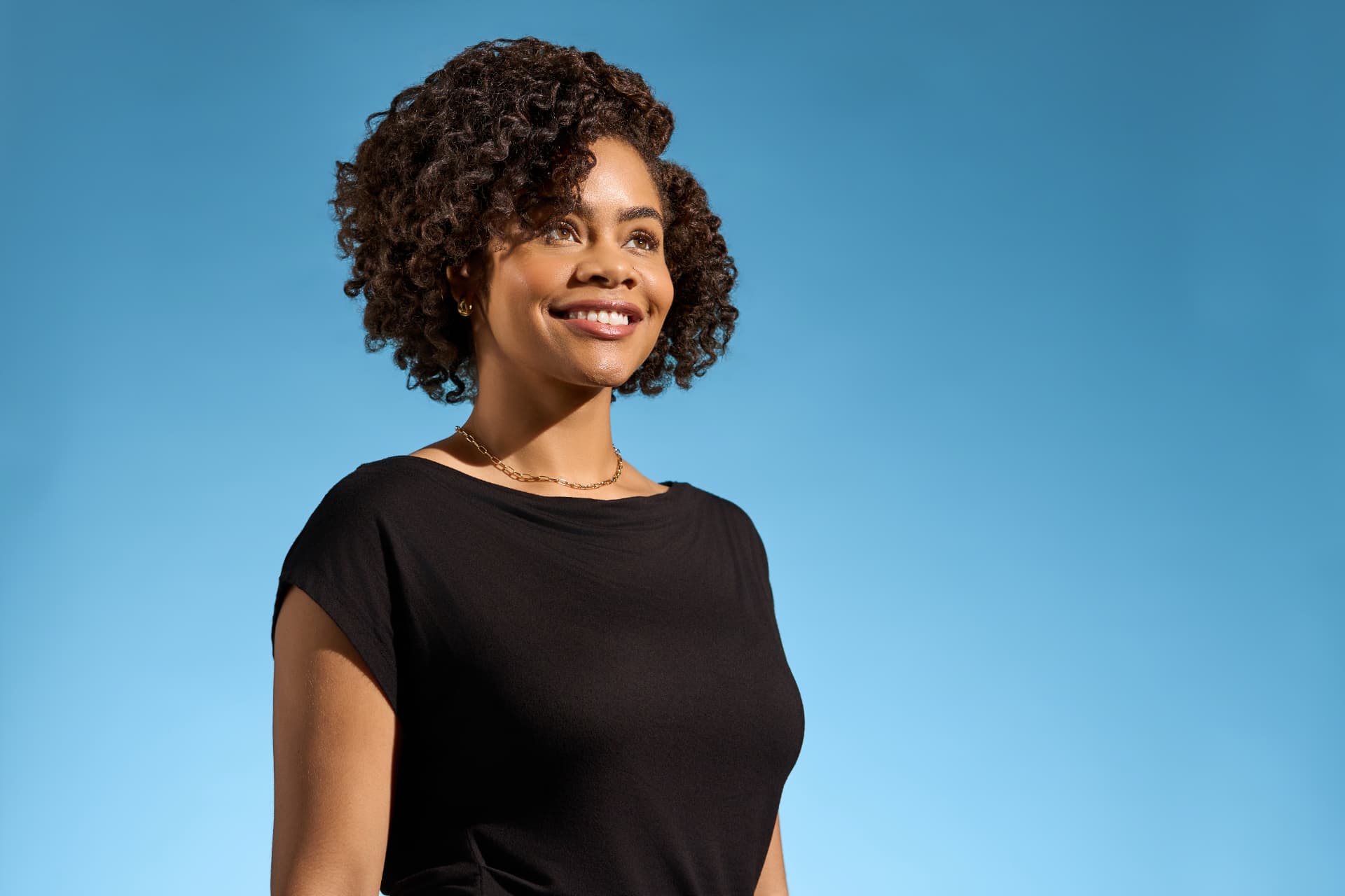 Mujer sonriendo con rizos naturales