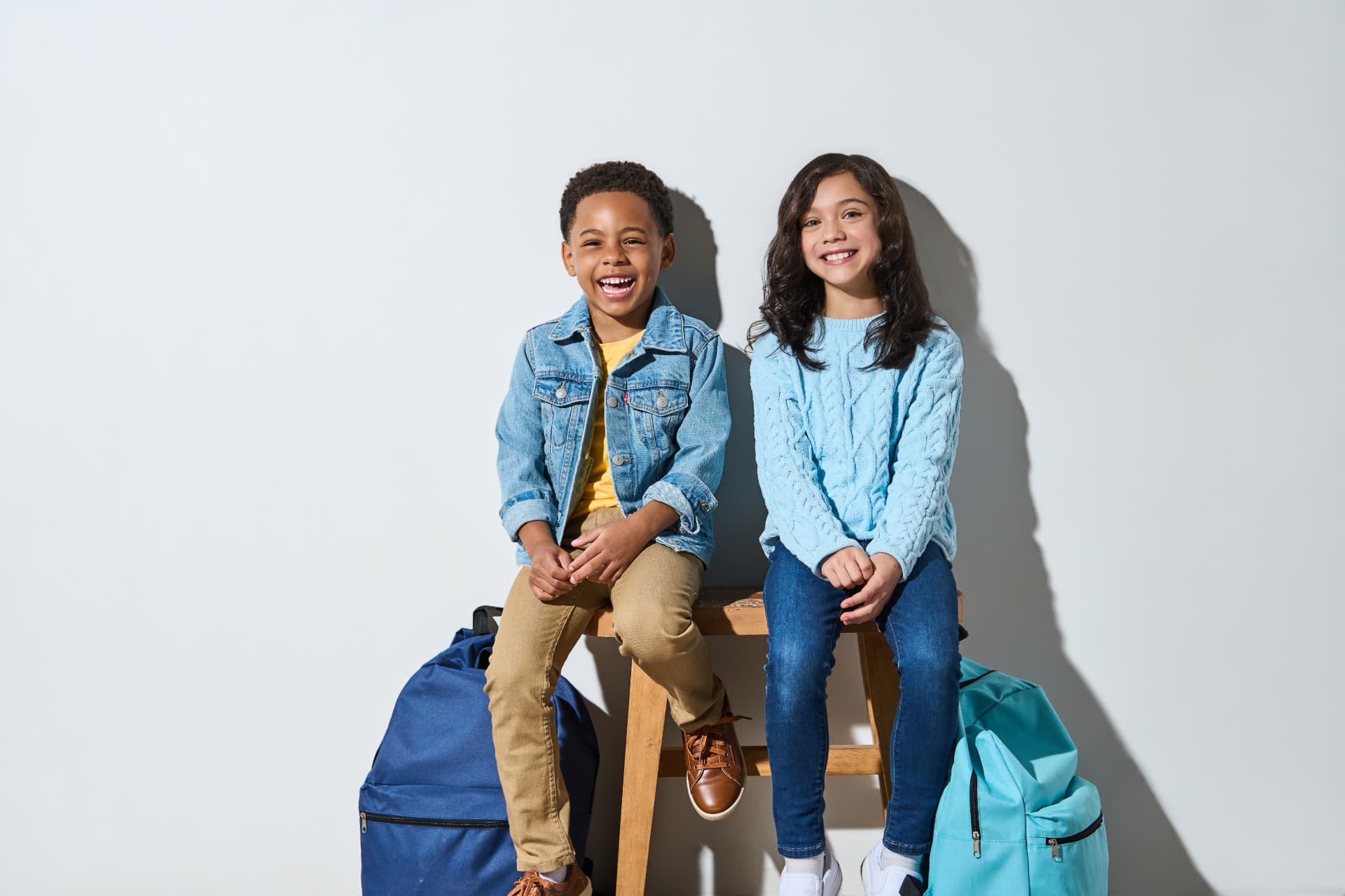 Two kids smiling after back-to-school haircuts